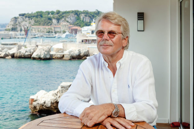 Photograph of man sitting at a table by the sea